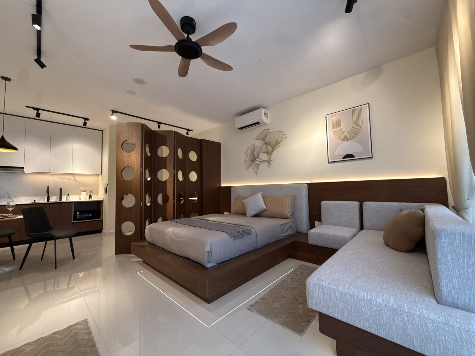 Renovated Edelweiss Tropicana Gardens studio by RenoXpert with platform bed and L-shaped sofa
